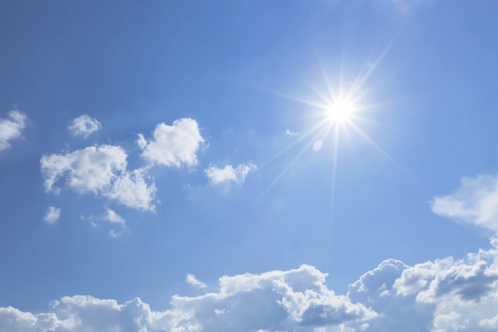 zon in blauwe lucht met wolken